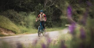 Marin Ambassador Juliet Elliott riding a Larkspur E on a gravel road.