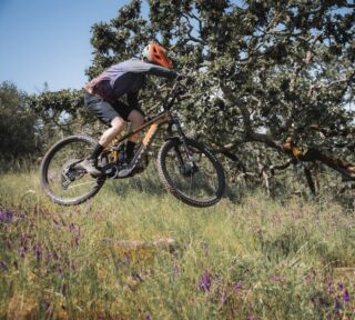 Man airborne on a Rift Zone EL XR eMTB after hitting a jump.