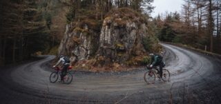 Bikepackers rounding a switchback on a gravel road.